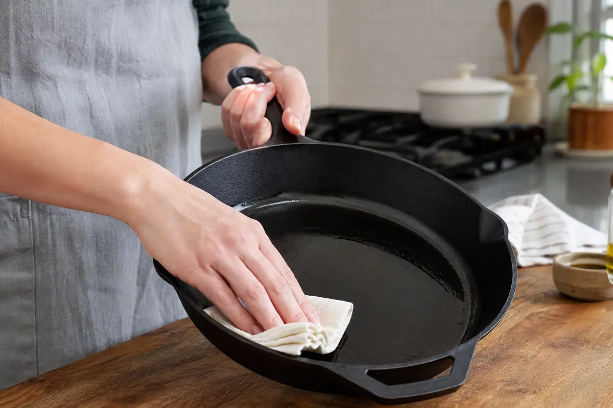 Applying a very thin coat of oil to a cast-iron skillet before seasoning